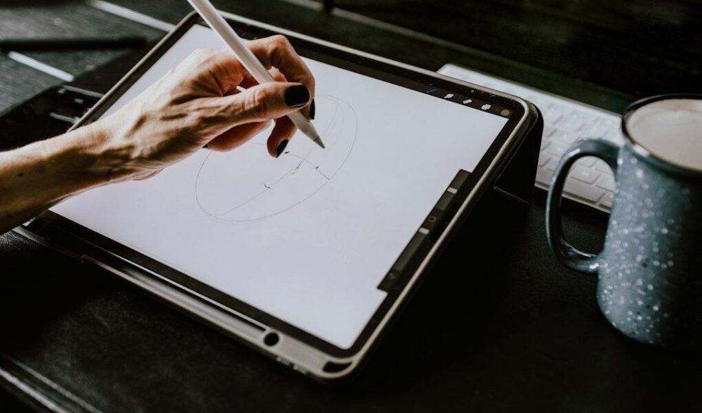 Hand zeichnet mit einem Eingabestift auf einem Grafiktablet