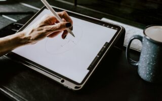 Hand zeichnet mit einem Eingabestift auf einem Grafiktablet